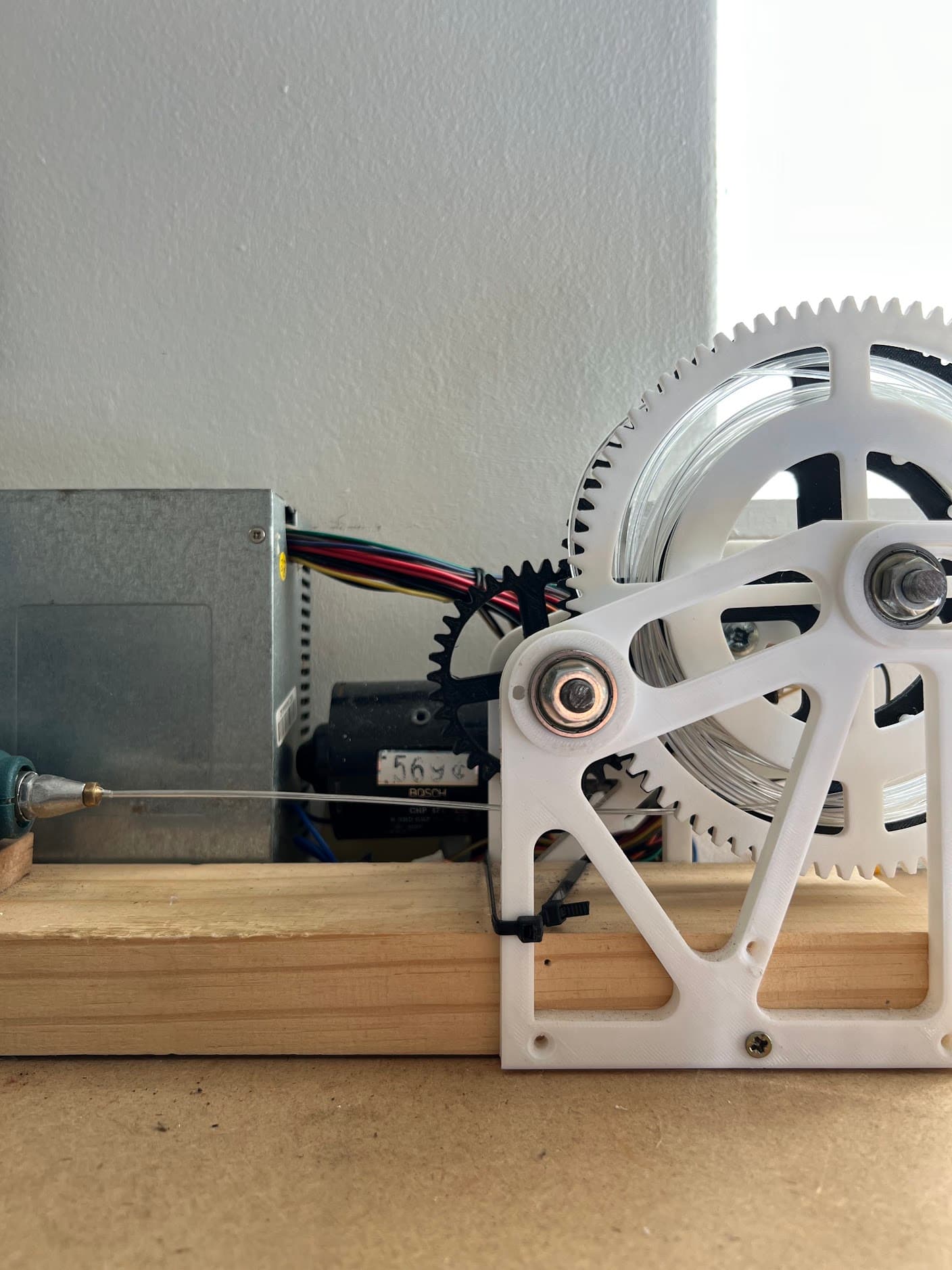 The custom-built pull-truder drawing filament from a strip